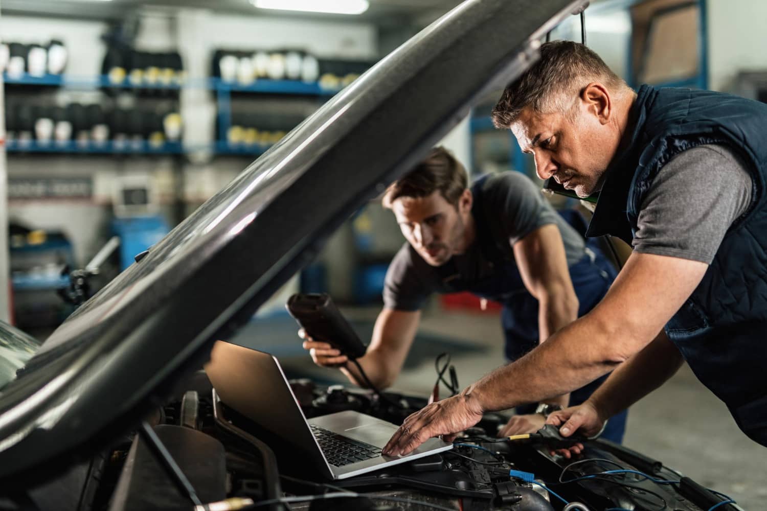 auto-mechanic-using-laptop-cooperating-with-coworker-while-doing-car-diagnostic-repair-shop (1)